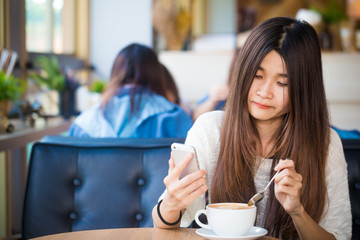 Asian beautiful women talking on smart phone while sitting in cafe