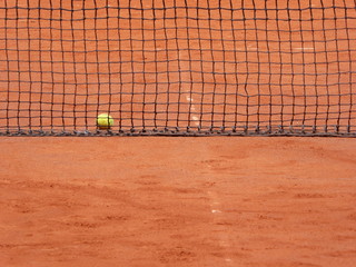 Ball and net on the clay tennis court