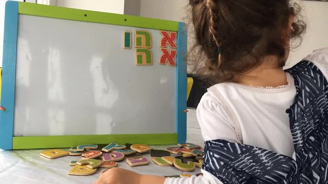 Little girl play with the Hebrew Alphabet letters