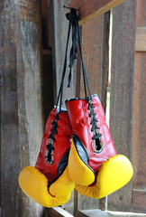 Pair of red-yellow boxing gloves Hanging on wooden.