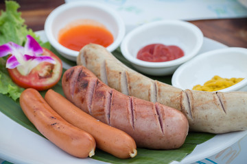 Grilled sausages and vegetables. Grilled pork sausages. Sausages serve with spicy sauce.Delicious german sausages.(selective focus)