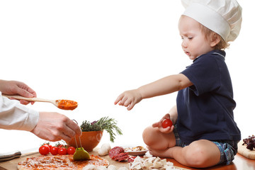 Child in the cook cap with him mother cook pizza. Isolated on white