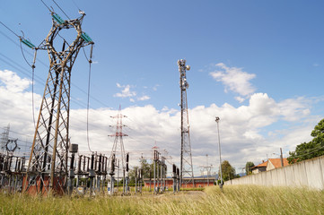 Centrale elettrica con sfondo cielo azzurro e nuvole bianche