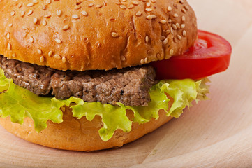 Sandwich with meat, green salad and tomato.