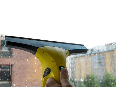 Cleaning windows with vacuum cleaner. Mixed white background.