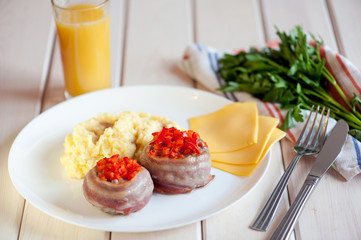 New portioned snack with bacon on a white wooden table