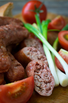 
Sausages with vegetables on a wooden texture