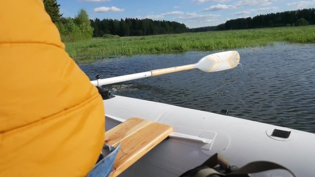 Man Rowing Inflatable Boat with Wooden Oars on Lake. Back View HD Slowmotion Lifestyle Footage.