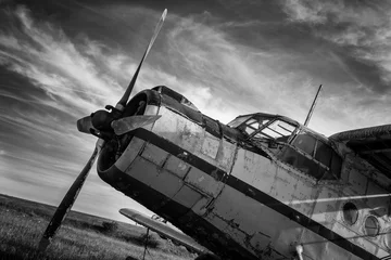 Foto op Plexiglas Oud vliegtuig Old airplane on field in black and white