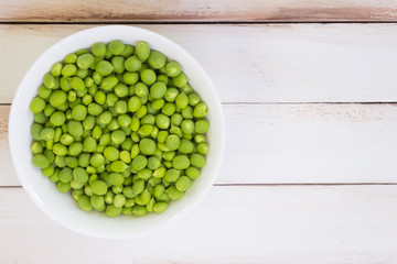 Fresh green peas on a wooden table