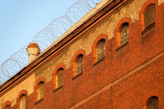 The outside view of an old and abandoned jail in Berlin during sunset