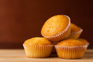 Fragrant cupcakes lie on a wooden table.