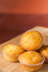Fragrant cupcakes lie on a wooden table.