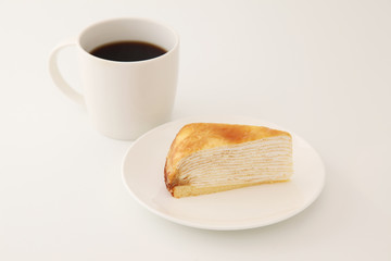 お皿にのせたミルクレープとホットコーヒー 白背景