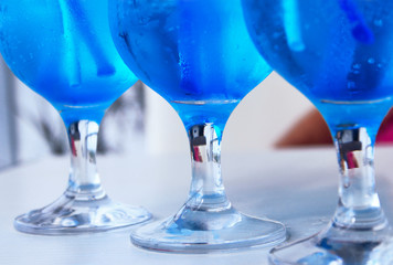 Restaurants, bars, cocktails background concept. Shot of a glass of alcohol on a countertop. Cropped shot of three glasses of blue cocktails on the table.