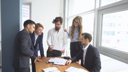 Group of business people discussing business issues. Working atmosphere in the office. Employees to view documents in the workplace.