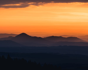 Tranquil landscape of mountains silhouettes during sunrise