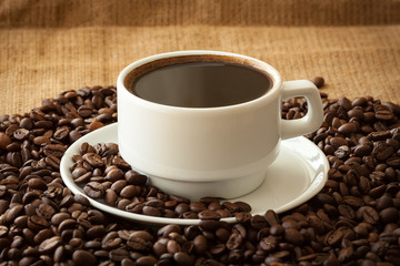 Coffee in white cup on fabric background.
