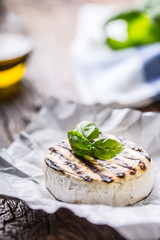 Camembert cheese. Grilled camembert cheese with olive oil and basil leaves.