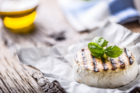 Camembert cheese. Grilled camembert cheese with olive oil and basil leaves.