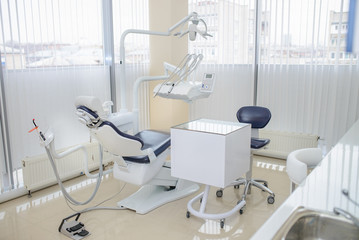 Modern dental clinic interior. Dental chair and other accessories.