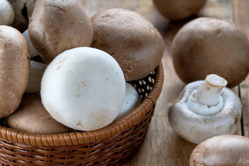 Champignons, mushrooms in the wicker basket and on wooden table