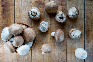 Champignons, mushrooms in the wicker basket and on wooden table