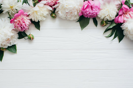 White and pink peonies on a wooden background.