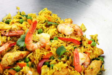 Udon stir-fry rice with shrimp and vegetables in wok pan on black burned stone background