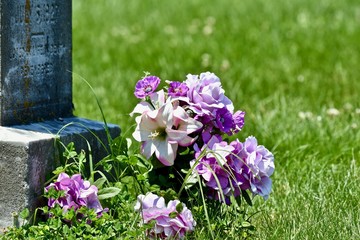 Bouquet of flowers next to headstone 