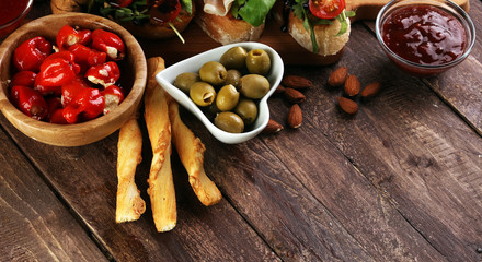 Italian antipasti wine snacks set. Cheese variety, Mediterranean olives, pickles, Prosciutto di Parma, tomatoes, artichokes and wine in glasses
