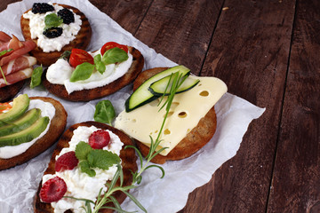 Bread Brushetta or authentic traditional spanish tapas set for lunch table. Sharing antipasti on party or summer picnic time over wooden rustic background.