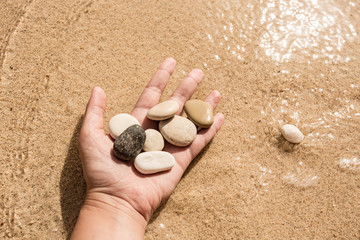 Pebble in the woman hands. Turkey, Kas, Kaputas beach.