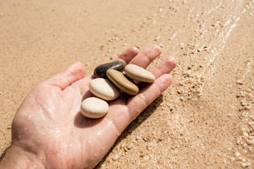 Pebble in the woman hands. Turkey, Kas, Kaputas beach.
