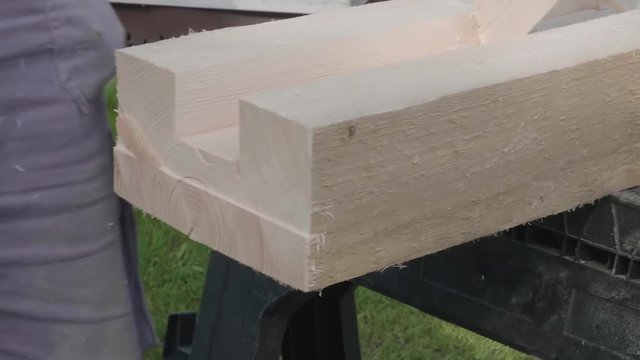 Hand of carpenter working with chisel outside.