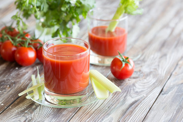 Tomato juice in a glass with celery and tomatoes