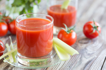 Tomato juice in a glass with celery and tomatoes
