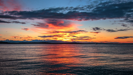 Alki Beach Sunset with Olympic Range Silhouetted and Water Reflections. .