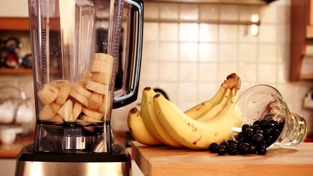 Making fresh banana bilberry fruit shake milkshake at home in blender high speed machine. Healthy eating, vegetarian food, diet concept. 4K ProRes HQ codec