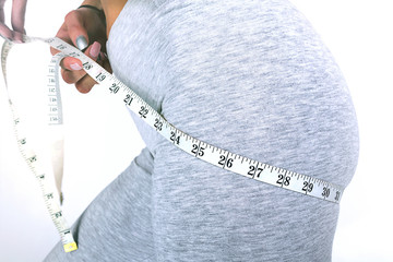 Hand with meter, buttocks and legs of slim woman