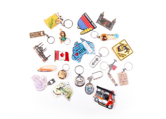 Various souvenirs fridge magnet and key chains from world countries on a white background