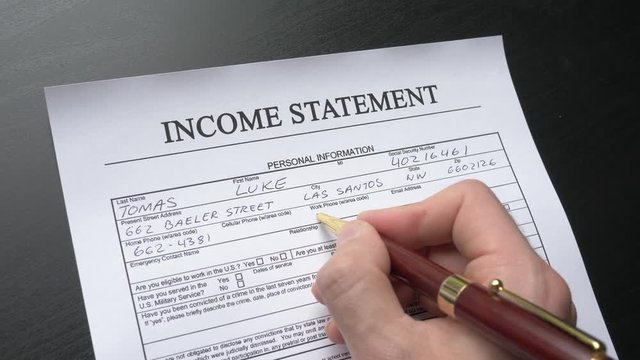 A person filling an income statement form. Closeup shot.
