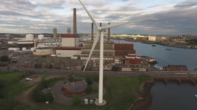Aerial shot of a spinning windmill with Boston downtown skyline in the background