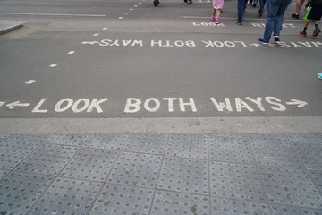 text look both ways in white letters on asphalt of street in London
