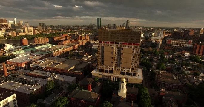 Aerial shot flying towards and over a building to reveal Boston Skyline and Charles River