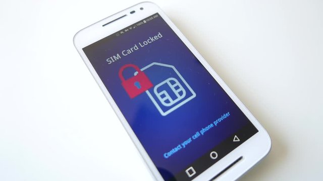 Smartphone on a table showing a message about a locked SIM card that is not working.
