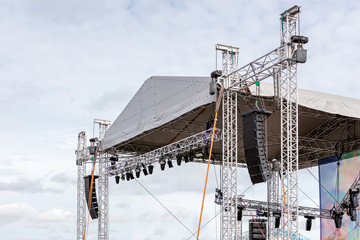 professional lightning and sound equipment mounted on outdoor stage on sky background