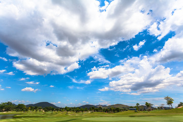 white clouds in blue sky above the golf field