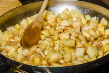 Fresh apples cut up being cooked into sauce