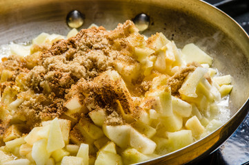 Fresh apples cut up being cooked into sauce